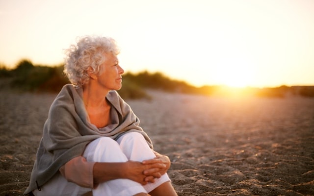 older woman enjoying a sunset on holiday older woman enjoying a sunset on holiday