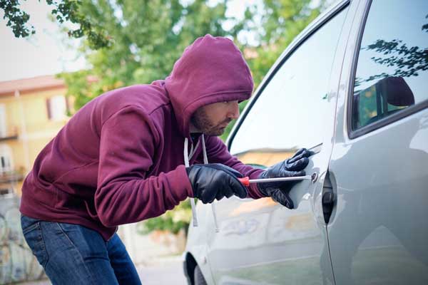 Thief breaking into a car