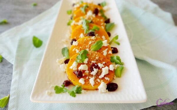 Snijd de hals van de pompoen(en), schil de hals en snijd deze in plakken van ongeveer 1 cm. -- Bak de pompoenplakken in 1 grote of 2 kleinere bakpannen met een scheutje olijfolie, een klontje boter, de tijmblaadjes, en chilivlokken en zout. -- Bak ze ongeveer 20-30 minuten tot de plakken zacht zijn en goudbruin aan beiden kanten. -- Doe de cranberries en granaatappelmelasse met 2 eetlepels heet water ondertussen in een jampotje en laat even weken. -- Leg de pompoenplakken op een warme schaal en serveer ze met de cranberries en granaatappelsiroop, verkruimelde feta, de verse kruiden en dukkah. -- Druppel als laatste de overgebleven olie uit de pan over de pompoen.