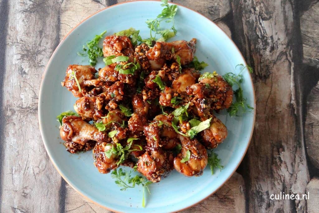 Kipkluifjes met pittige zoete saus, pinda's en koriander