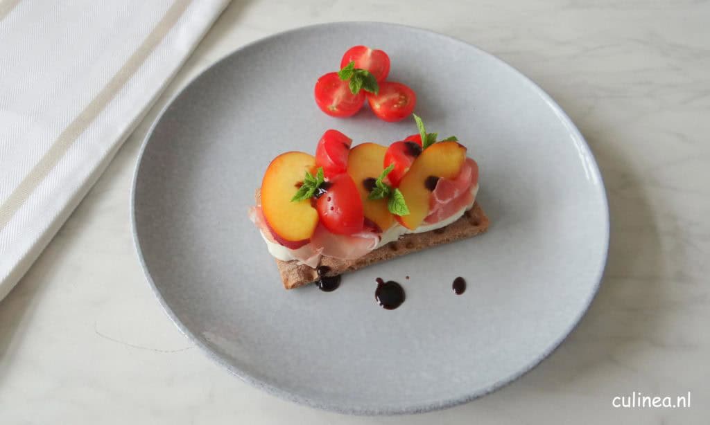 Knäckebröt met burrata, rauwe ham, nectarines en tomaatjes