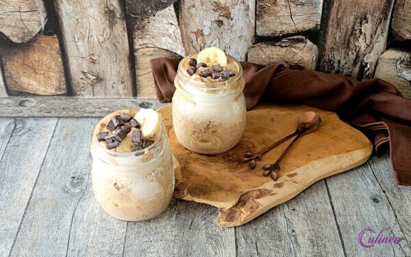 Meng de havermout, melk, agavesiroop en de kaneelpoeder in een kom. Snijd of prak de helft van de banaan fijn en meng dit samen met 1 eetlepel pindakaas ook hierdoor. -- Giet of lepel het mengsel in 2 glaasjes of schaaltjes. Snijd de rest van de banaan in stukjes en lepel dit op de havermout. Zet dit een nacht afgedekt in de koelkast. -- Haal de het de volgende morgen uit de koelkast en lepel op elk glaasje een beetje pindakaas. Bestrooi met wat chocodrops en genieten maar.