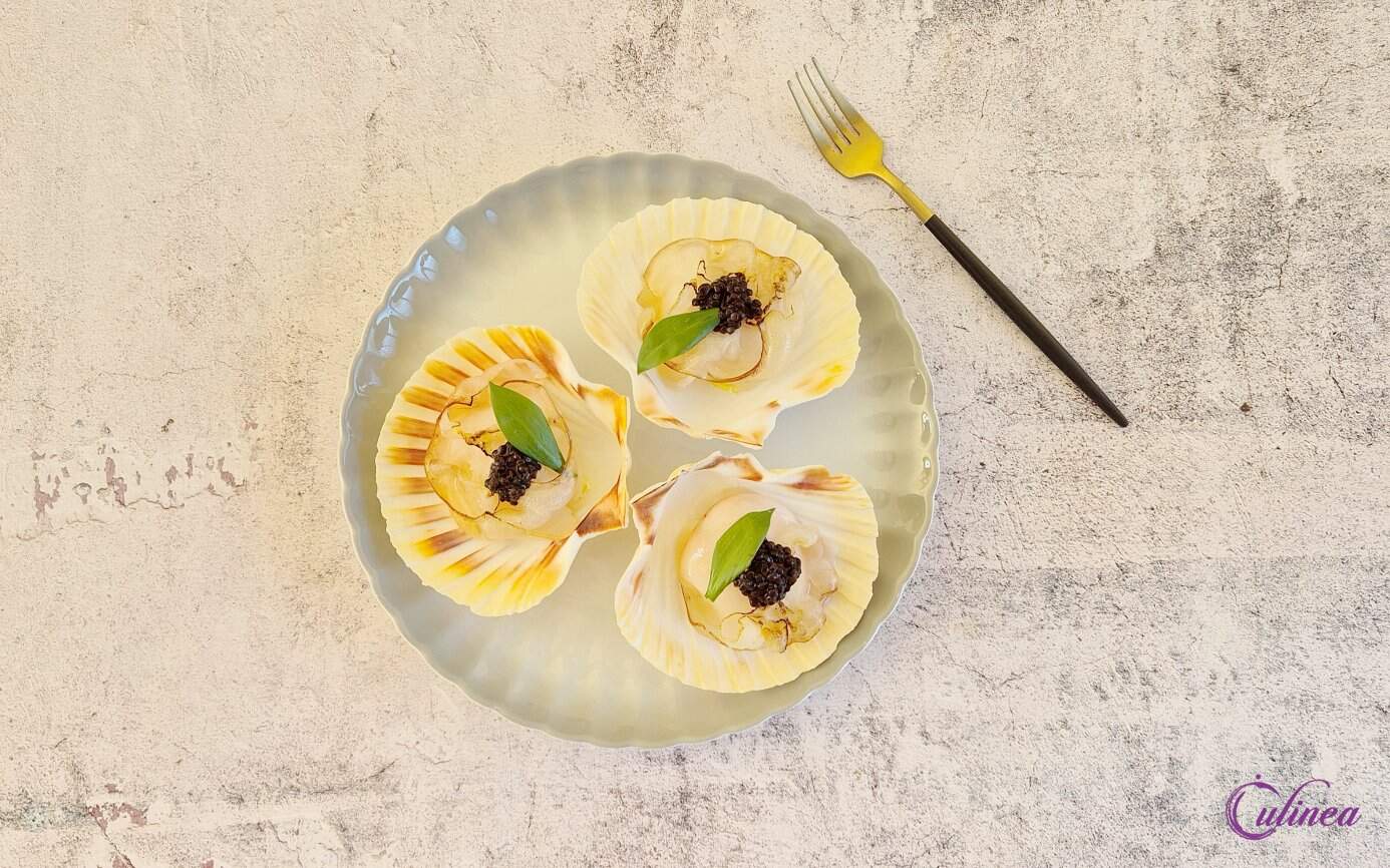 Coquilles met gebrande lardo op een bord